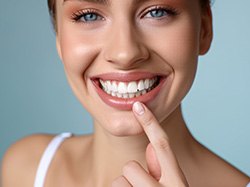 Smiling woman pointing at her teeth
