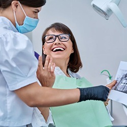 Happy patient and dentist looking at X-ray