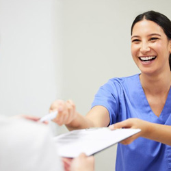 Dental team member handing clipboard to patient