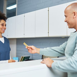 Man providing payment at dental office front desk
