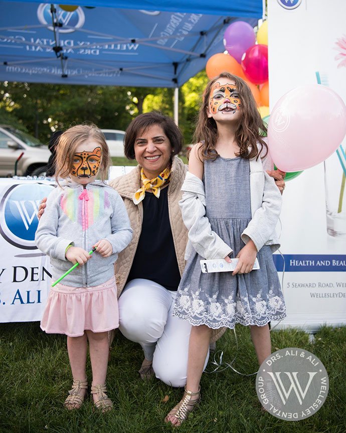 Dentist and two young patients at community event