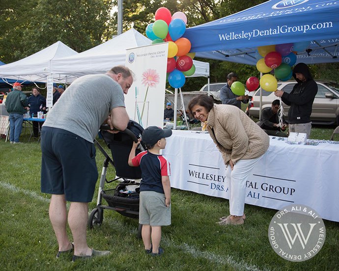 Dentist talking to young person at community event