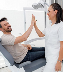 Patient high-fiving dental team member