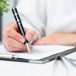 Dentist taking notes during consultation with patient