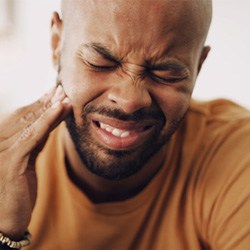 Pained man suffering from symptoms of late-stage gum disease