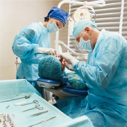 Two dentists conducting osseous surgery for patient with gum disease 