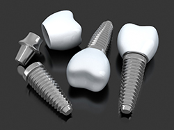 Several single tooth dental implants in Wellesley on dark gray background 