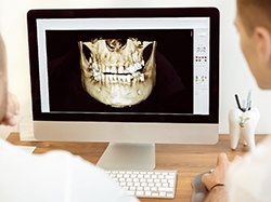 Wellesley implant dentist pointing at an X-ray with patient watching