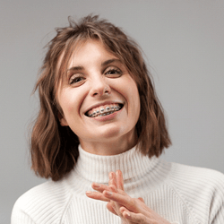 Smiling woman with braces on her upper and lower teeth