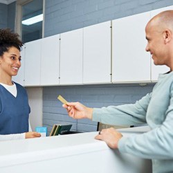 Person paying for treatment at dental office front desk