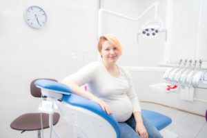 Pregnant woman sitting upright in dental treatment chair