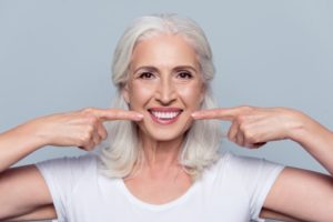 Smiling older woman, showing her dental implants