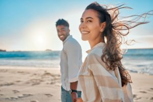 Happy couple enjoying walk on beach