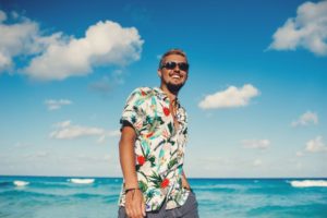 Man walking on beach, smiling happily