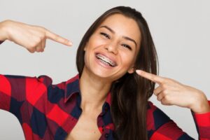 Happy young woman pointing at her braces 