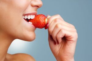 Woman biting into a strawberry 